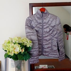 Designer Bernardo silver quilted jacket with a bag to carry the  jacket.